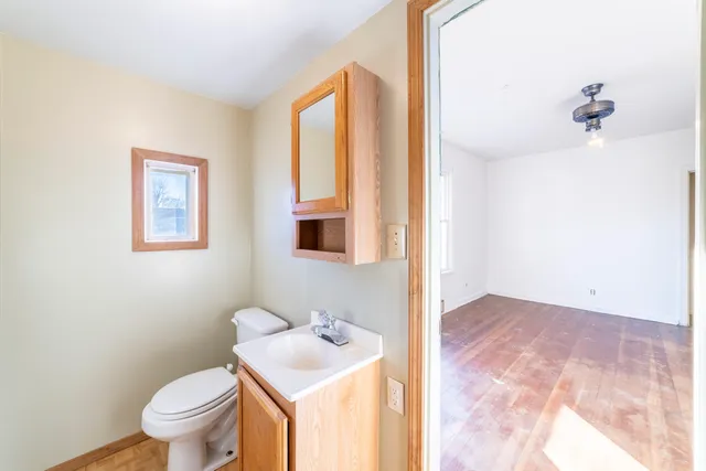 a bathroom with a toilet a sink and a mirror
