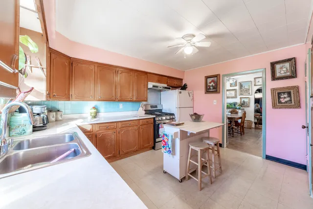 a kitchen with a dining table chairs cabinets and stainless steel appliances