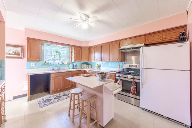 a kitchen with stainless steel appliances kitchen island granite countertop a sink stove and refrigerator