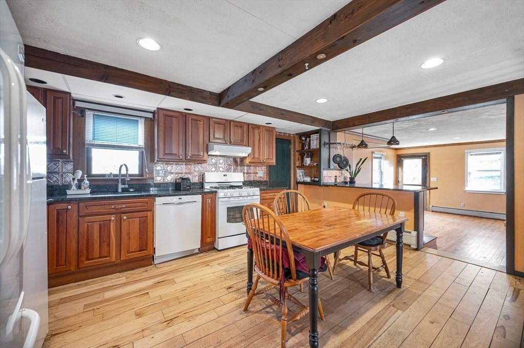 167 North Road Chelmsford, MA 01824 - Photo 12 of 38 a kitchen with stainless steel appliances granite countertop a kitchen island hardwood floor sink stove dining table and chairs