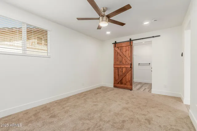 an empty room with closet and windows