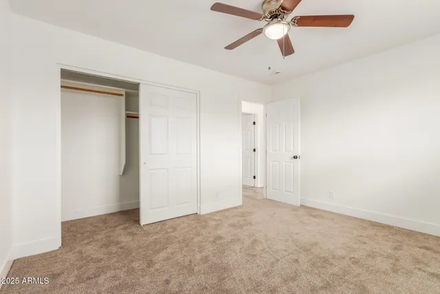 an empty room with chandelier fan
