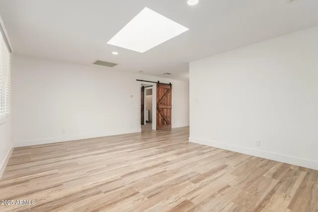 a view of an empty room with wooden floor