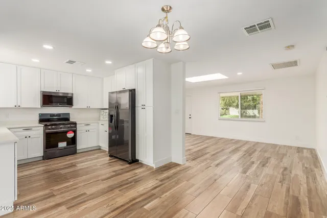 a view of a kitchen with wooden floor and a refrigerator