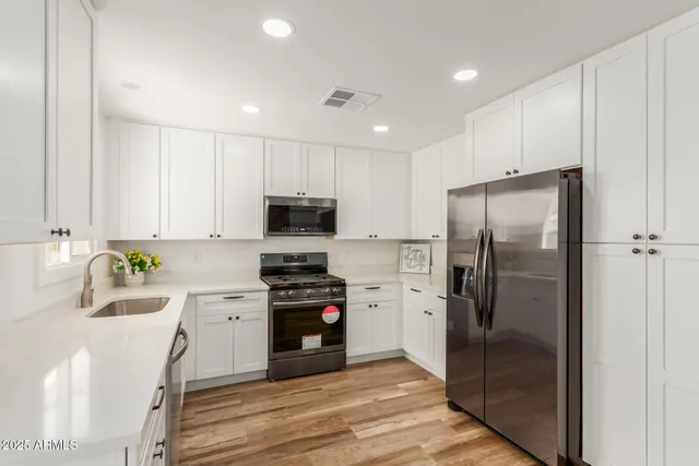 a kitchen with stainless steel appliances a refrigerator sink and stove