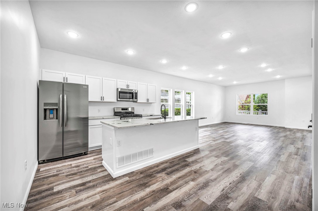 3709 Sudbury Road Cleveland, OH 44120 - Photo 12 of 29 Kitchen featuring white cabinetry, stainless steel appliances, and a center island with sink