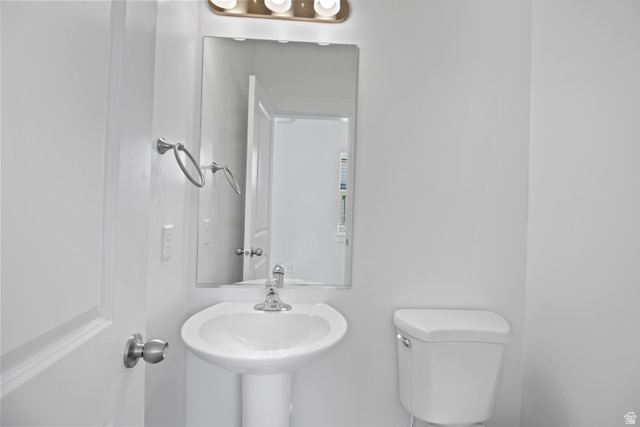 1271 West 500 South Logan, UT 84321 - Photo 10 of 26 Bathroom featuring a pedestal sink with chrome faucet, mirror, and overhead vanity lighting