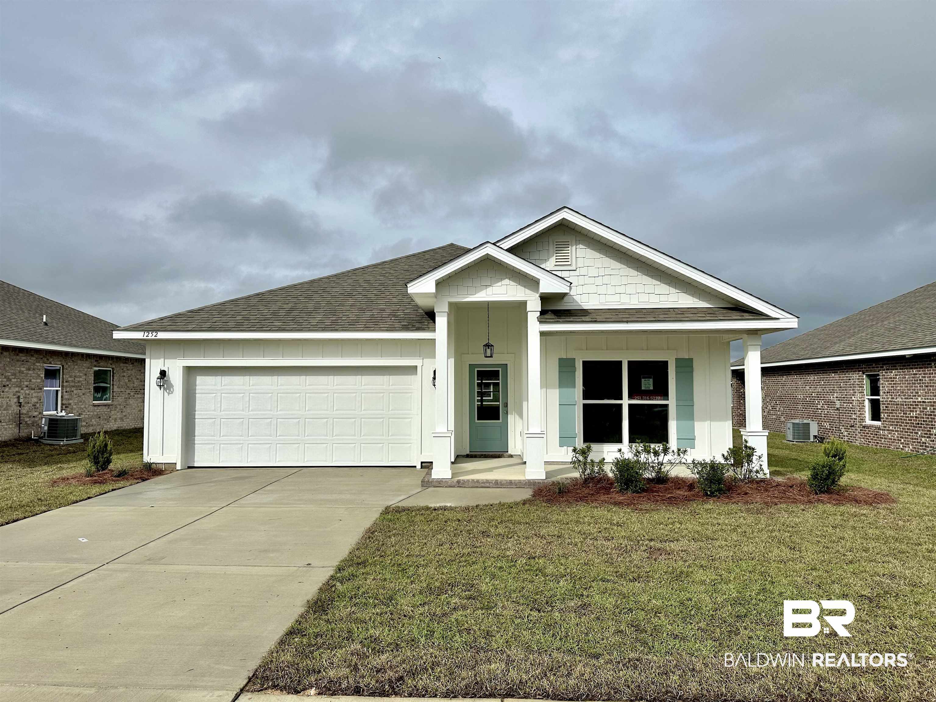 1252 Hayward Loop Foley, AL 36535 - Photo 1 of 44 View of front facade with central AC unit, a garage, a front lawn, and a porch