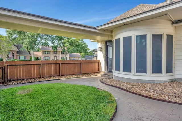 a view of a backyard with plants and wooden fence
