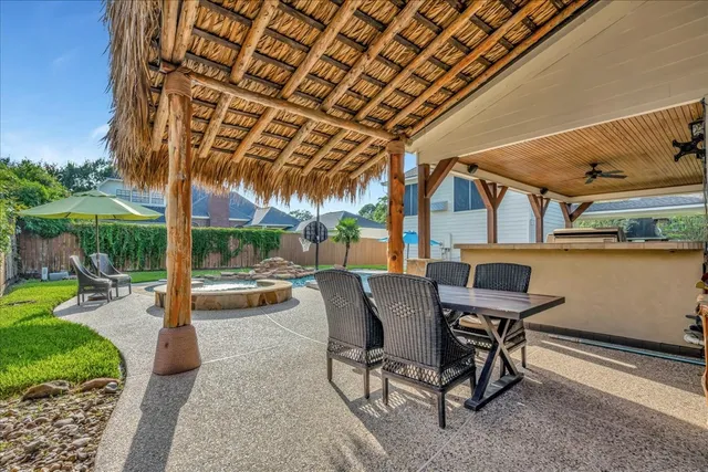 a view of a patio with table and chairs barbeque potted plants and large tree