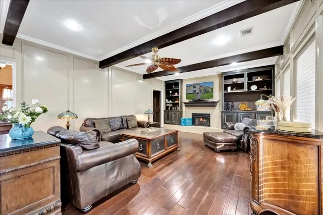 a living room with furniture large window and wooden floor