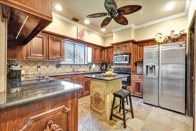 a kitchen with stainless steel appliances granite countertop a refrigerator a sink a stove and island