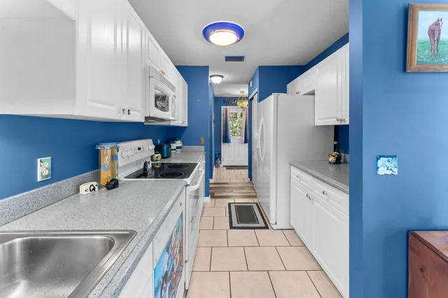 a kitchen with a sink a refrigerator and cabinets