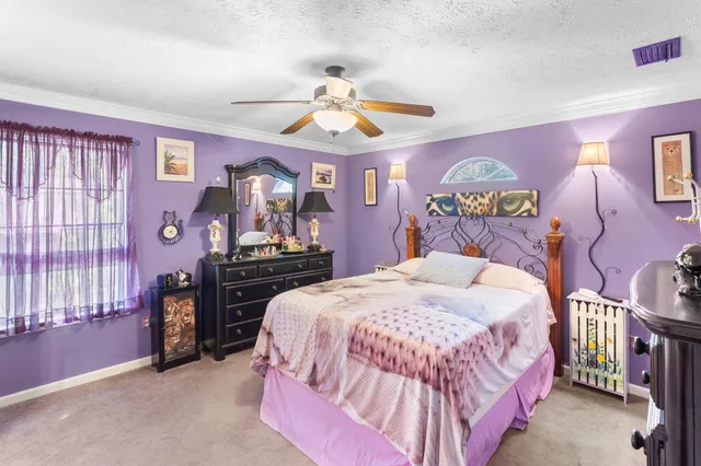 a bedroom with a bed and ceiling fan