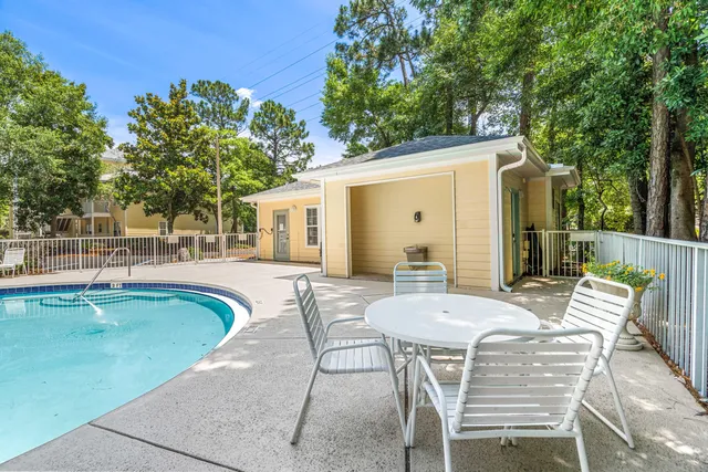 a view of a patio with table and chairs and potted plants with large tree
