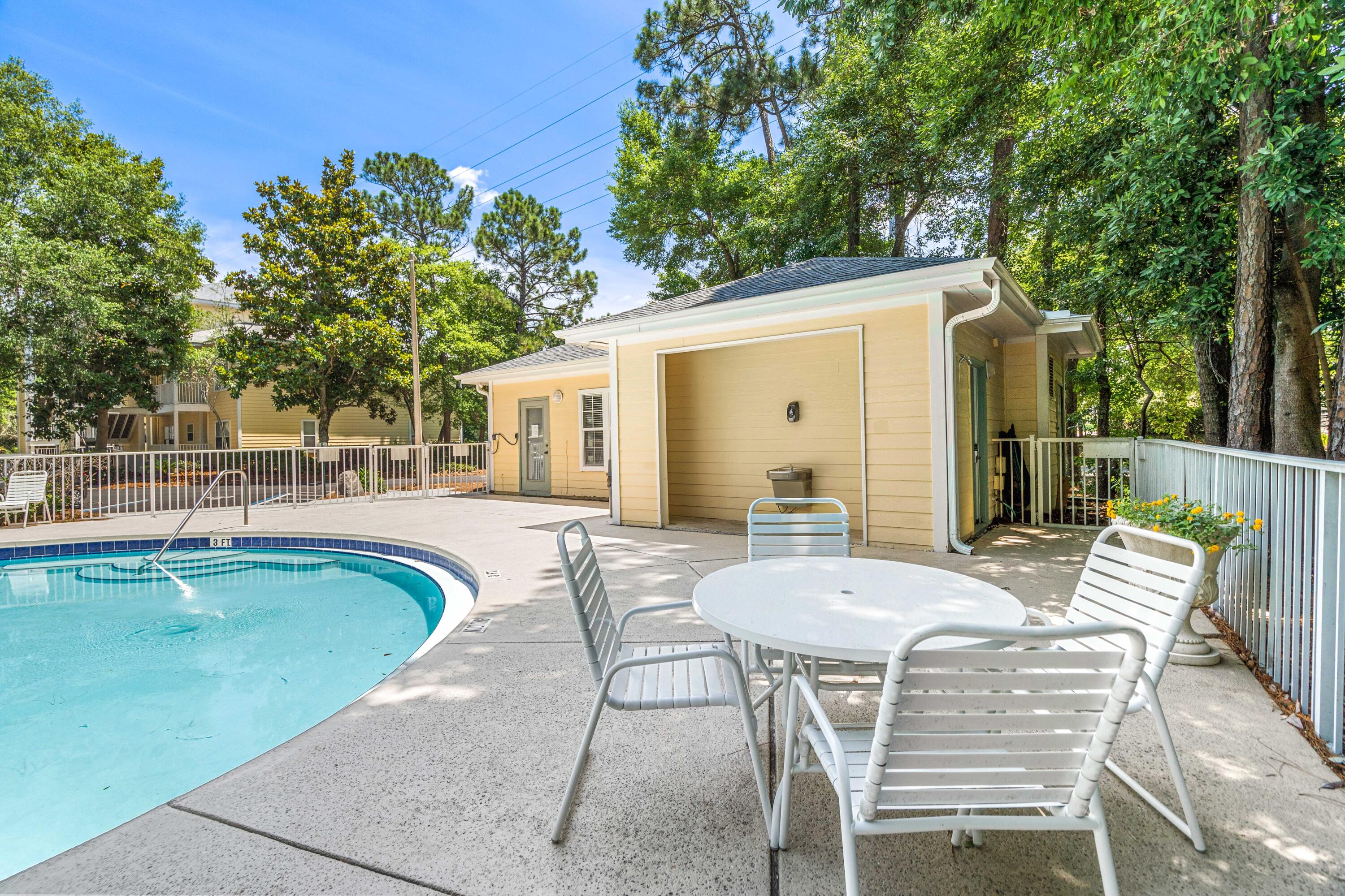 200 Sandestin Lane, Unit 1403 Miramar Beach, FL 32550 - Photo 27 of 37 a view of a patio with table and chairs and potted plants with large tree