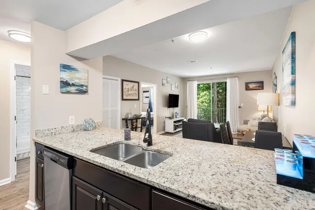 a kitchen with granite countertop a sink and white cabinets