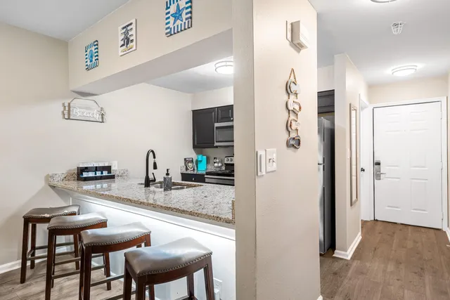 a kitchen with stainless steel appliances granite countertop a refrigerator and a stove