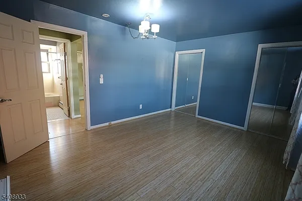 an empty room with wooden floor and a bathroom