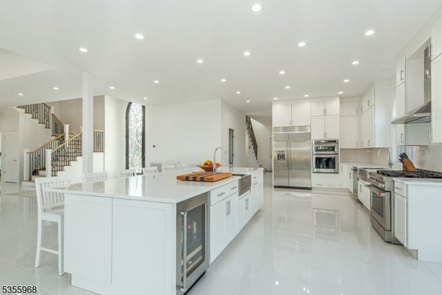 a kitchen with stainless steel appliances kitchen island granite countertop a stove and a sink