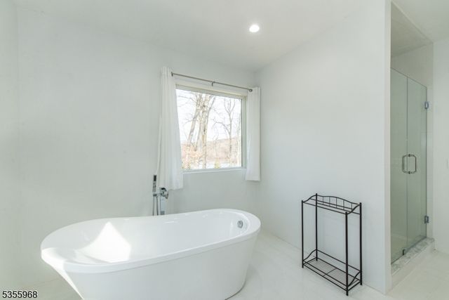 a bathroom with double vanity sink a mirror and a bathtub