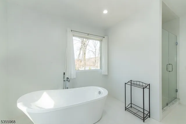 a bathroom with double vanity sink a mirror and a bathtub