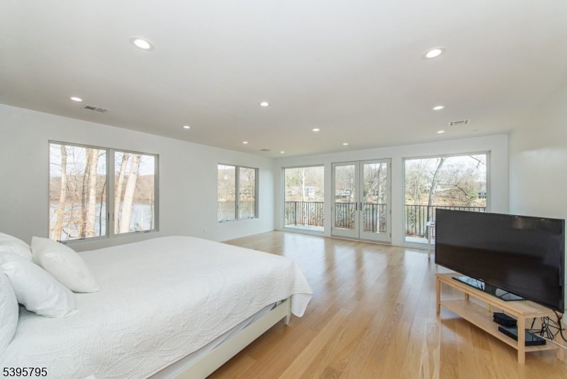 34 West Shore Road Mountain Lakes, NJ 07046 - Photo 25 of 50 a spacious bedroom with a large bed and a flat screen tv