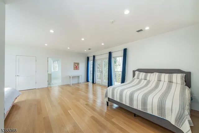 a bedroom with a bed and a wooden floor