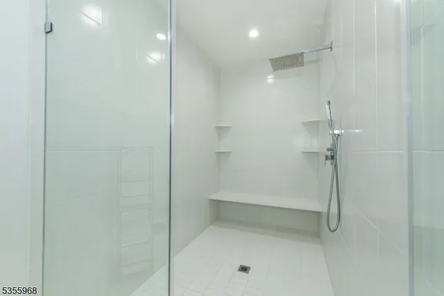 a bathroom with double vanity sink a mirror and a bathtub