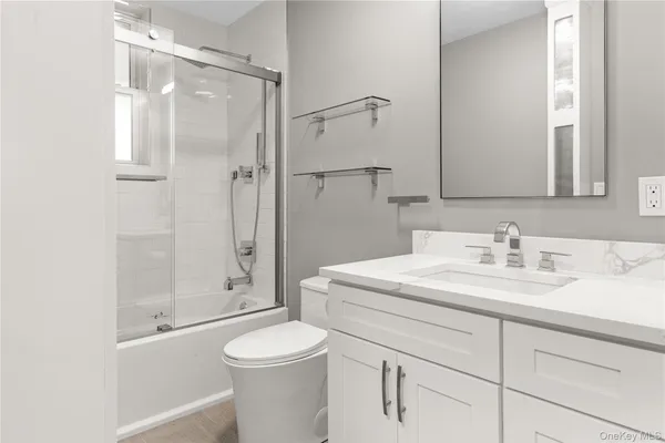 a bathroom with a sink a toilet and shower