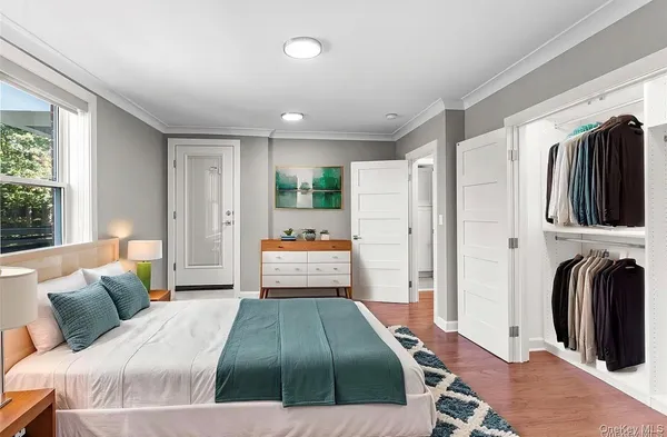 a bedroom with a bed a mirror and a flat tv screen