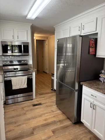 a kitchen with stainless steel appliances granite countertop a refrigerator stove and sink