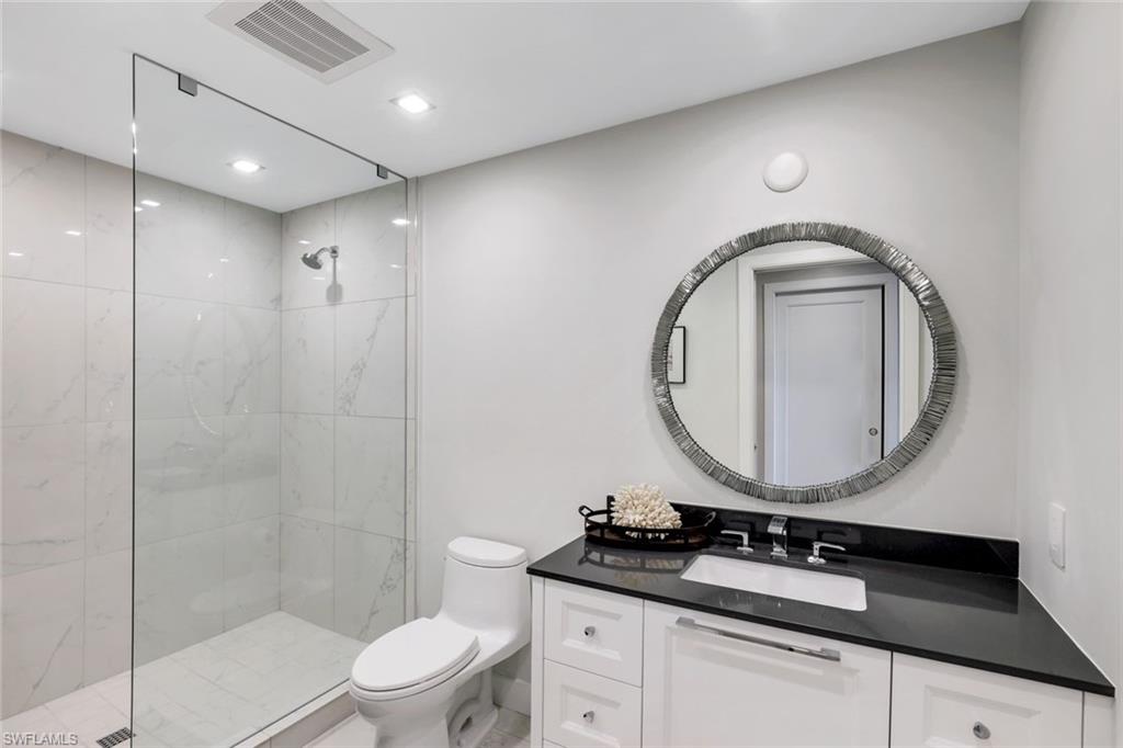 13915 Old Coast Road, Unit 502 Naples, FL 34110 - Photo 19 of 42 a bathroom with a sink vanity mirror and toilet