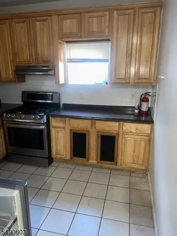 a kitchen with granite countertop a stove top oven microwave and cabinets