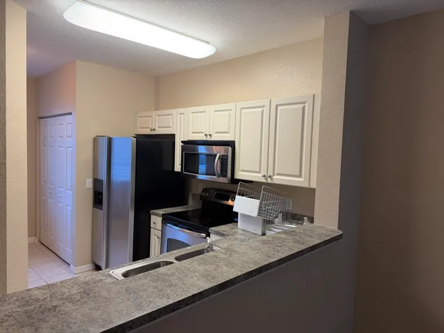 a kitchen with stainless steel appliances granite countertop a refrigerator and a sink