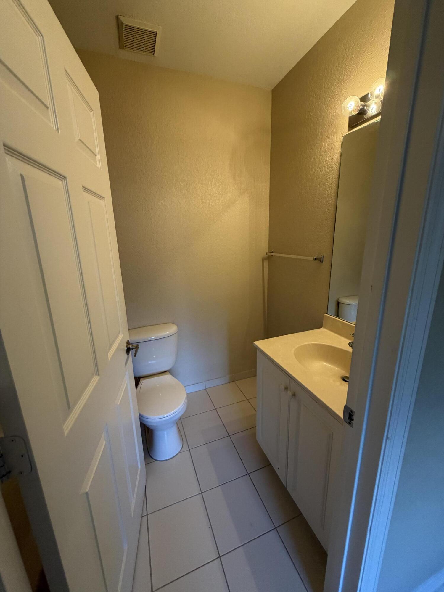 1992 Alamanda Way Riviera Beach, FL 33404 - Photo 2 of 13 a bathroom with a granite countertop sink and a toilet