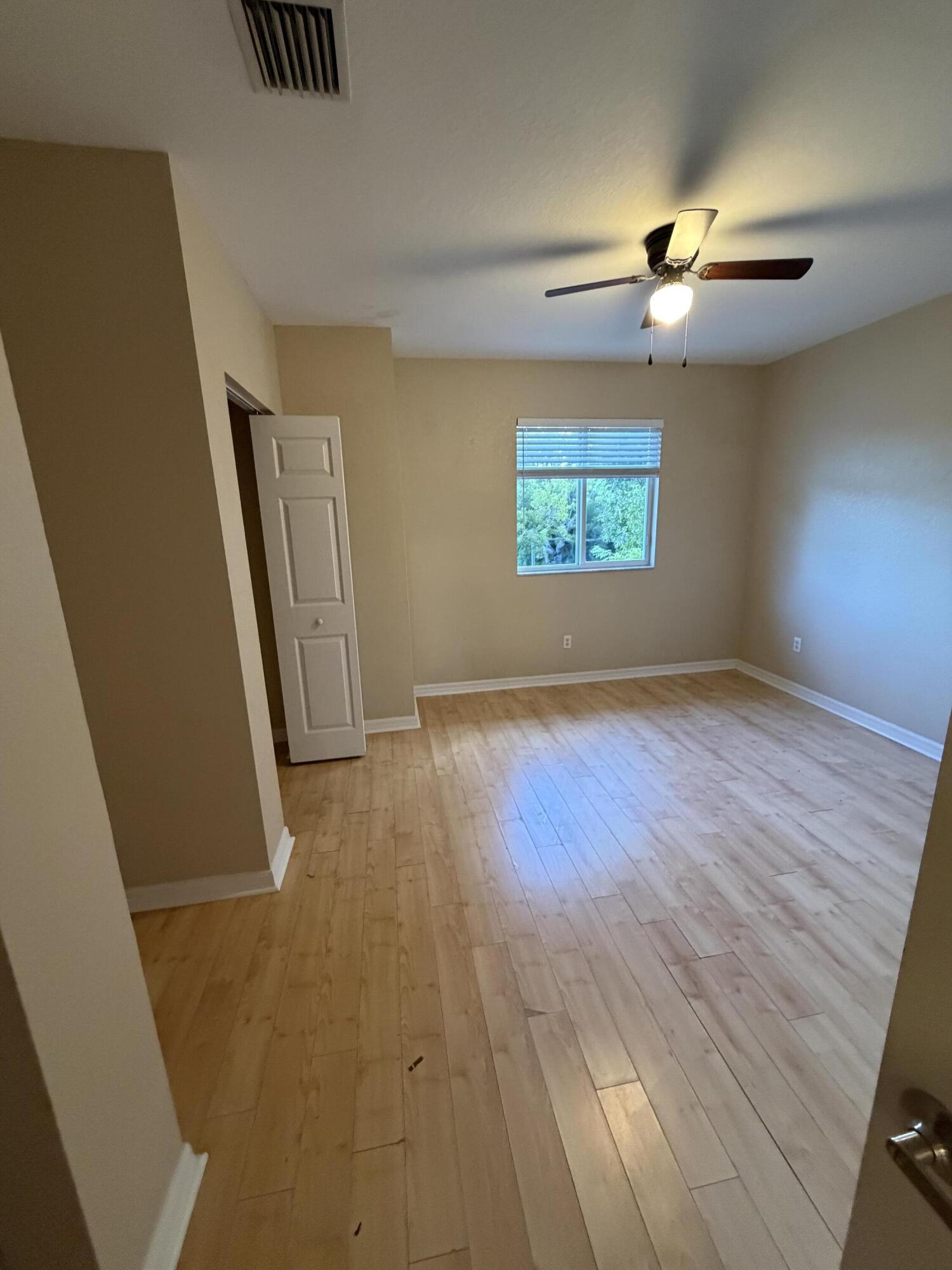1992 Alamanda Way Riviera Beach, FL 33404 - Photo 3 of 13 wooden floor in an empty room with a window