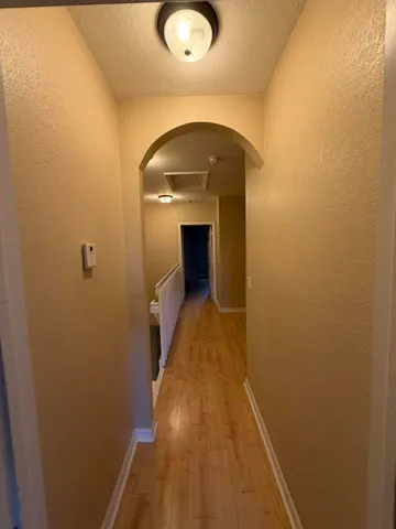 a view of a hallway with wooden floor and a staircase