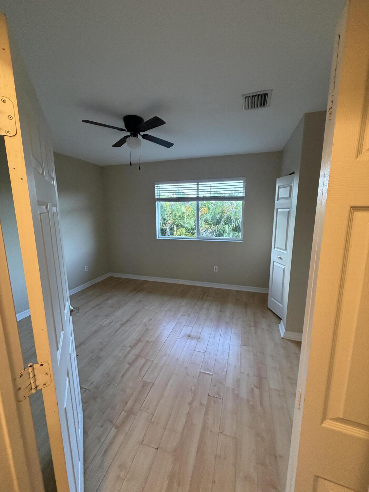 1992 Alamanda Way Riviera Beach, FL 33404 - Photo 8 of 13 an empty room with wooden floor and windows
