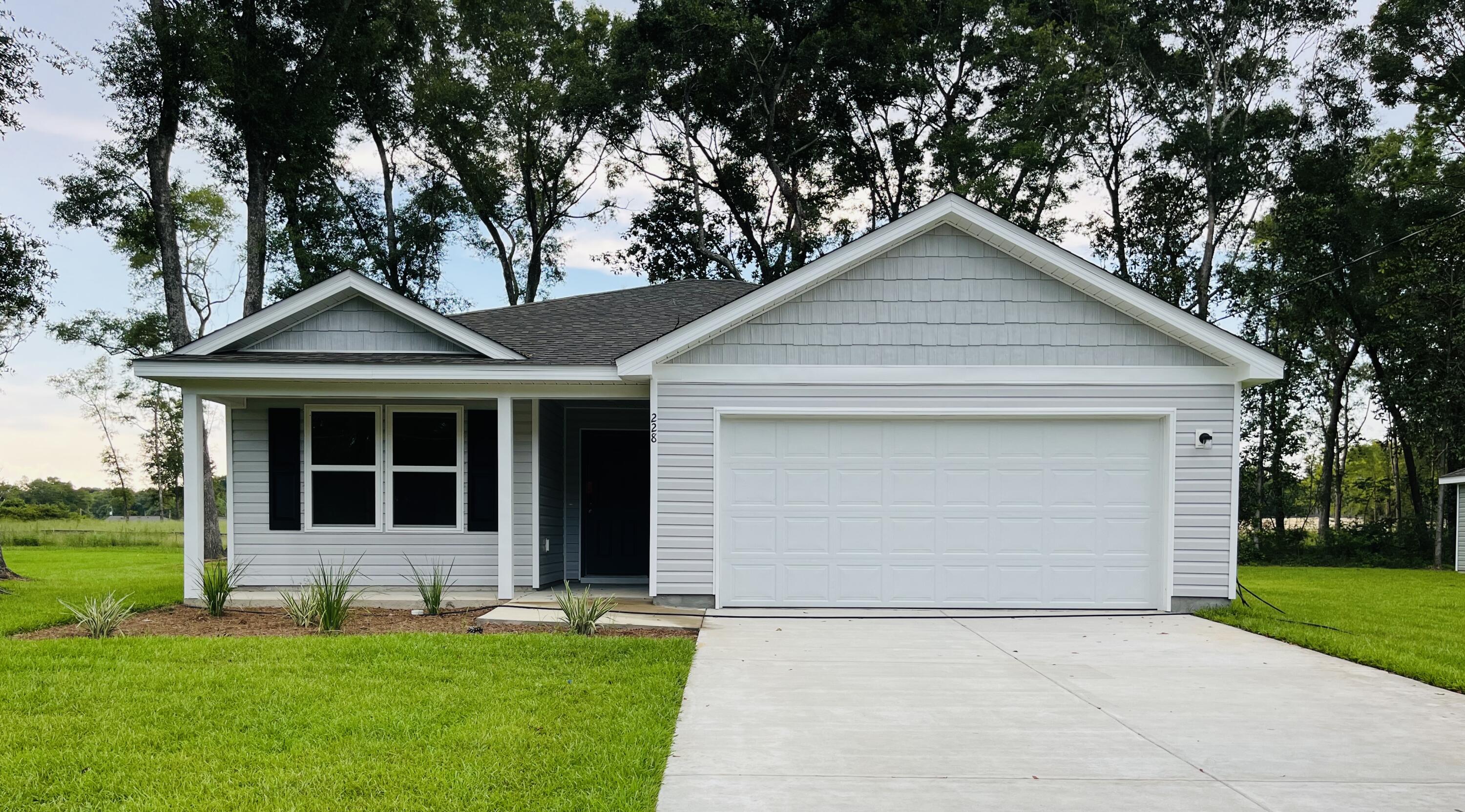 228 Squirrel Road DeFuniak Springs, FL 32433 - Photo 1 of 12 a front view of a house with a yard and garage