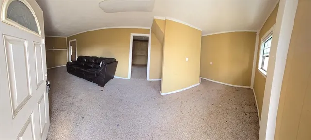 a living room with furniture a flat screen tv and a window