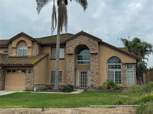 a front view of a house with a garden and plants