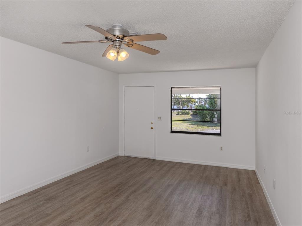 662 Substation Road Venice, FL 34285 - Photo 16 of 26 a view of an empty room with wooden floor and a window