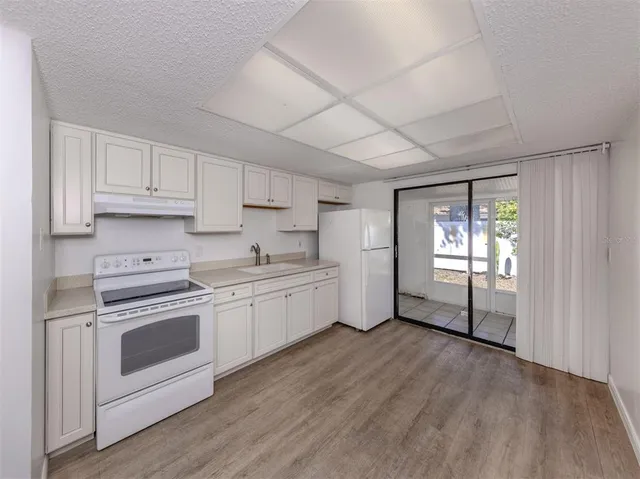 a kitchen with granite countertop white cabinets and white appliances