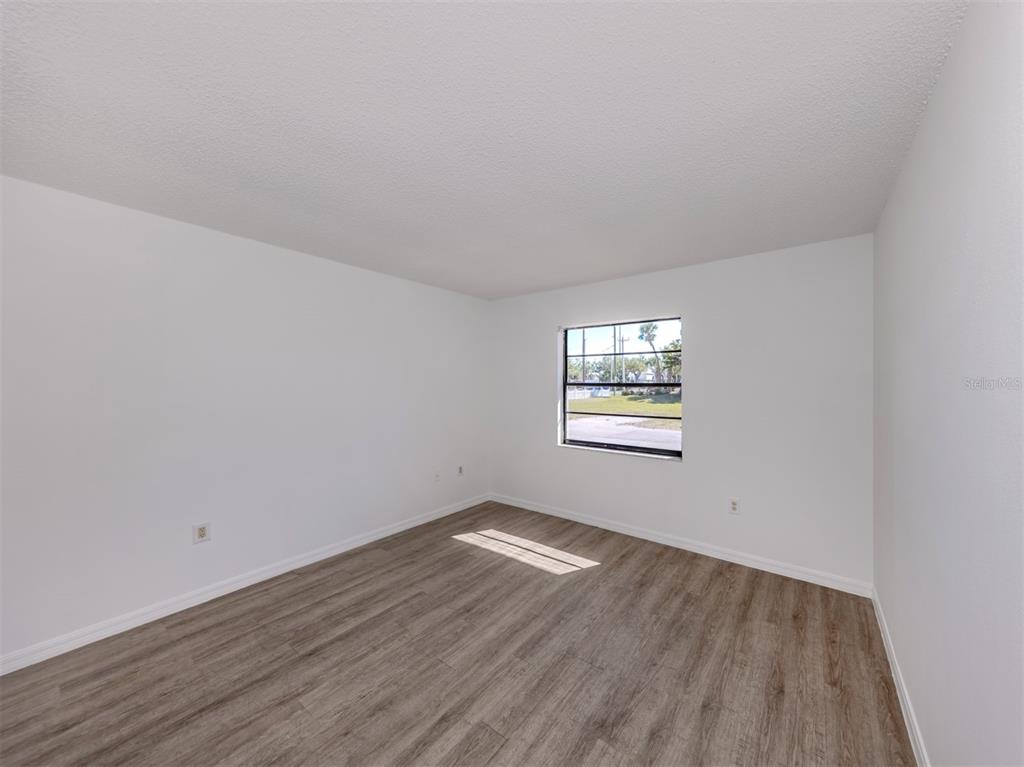 662 Substation Road Venice, FL 34285 - Photo 6 of 26 an empty room with wooden floor and windows