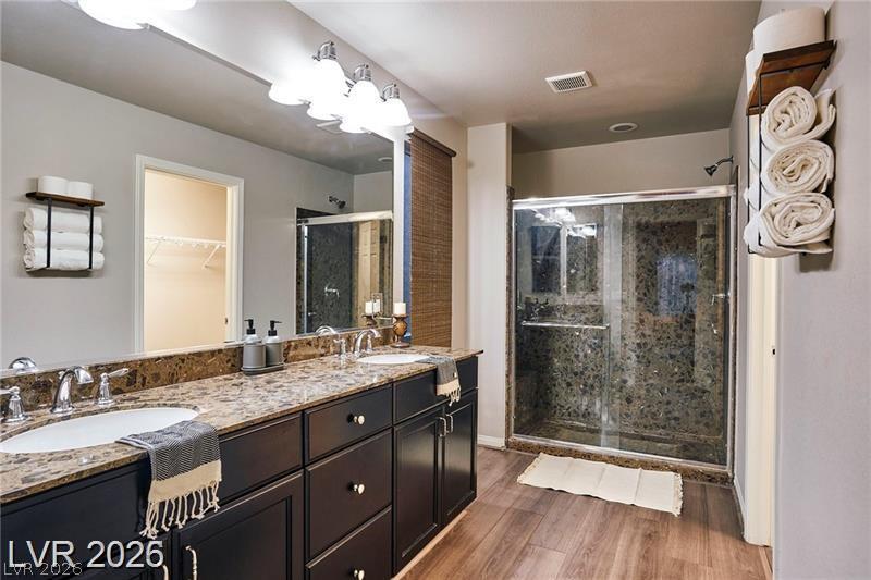 6302 Jackson Spring Road Las Vegas, NV 89118 - Photo 29 of 48 Dual vanities with granite counters complement a spacious walk-in shower in this appealing bathroom.