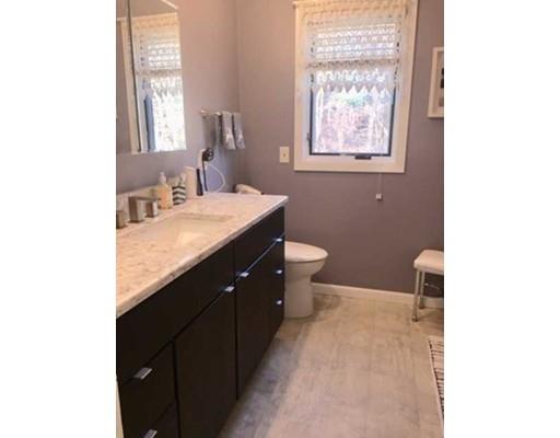 300 Putnam Hill Road Sutton, MA 01590 - Photo 15 of 21 a bathroom with a granite countertop sink a toilet a mirror and a window