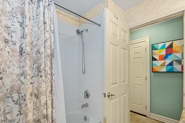 a bathroom with a painting on the wall and shower