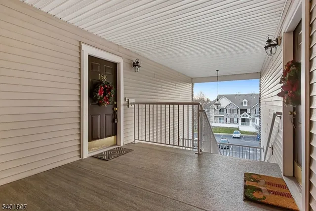 a view of a porch with wooden floor and a gate