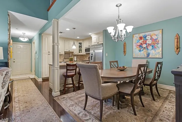 a view of a dining room with furniture a chandelier and wooden floor